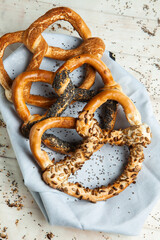 Fresh prepared homemade soft pretzels. Different types of baked bagels with seeds on a black background.