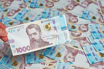 Man's hand holding Ukrainian banknote
