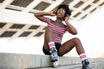 Beautiful African woman with roller skates. Urban sexy girl enjoy outdoors..