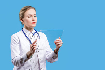 A female doctor looks into a tablet on a blue background. Analyzes from the laboratory. Hospital....