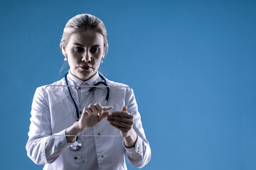 A female doctor looks into a tablet on a blue background. Chief Physician. Therapist. Analyzes from the laboratory. Hospital