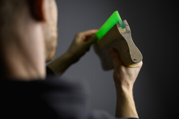 Cropped shot of blurred artisan touching rubber of squeegee isolated on grey 