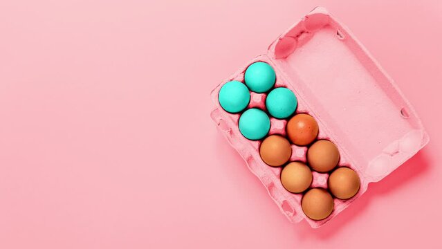 Easter holiday. Packaging of chicken eggs changing painting to blue on pink background. Copy space. Banner. Video footage. Gif. Religion concept. Mock up design. Minimalist modern style. Festive food.