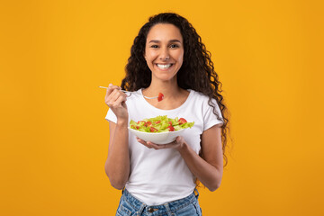 Portrait of Smiling Latin Lady Holding Plate With Salad