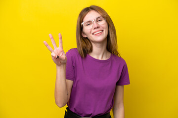Young English woman isolated on yellow background happy and counting three with fingers