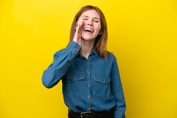 Young English woman isolated on yellow background shouting with mouth wide open