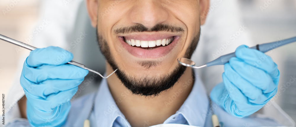 Wall mural Periodontal Services. Closeup Shot Of Smiling Man Getting Treatment In Stomatologic Clinic