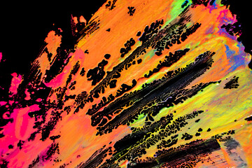 Abstract vibrant multi-color wet paint drops and splotch on black background. Bright orange and...