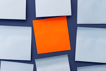 Blank orange sticky sticker among blue note papers. Important message or reminder, copy space