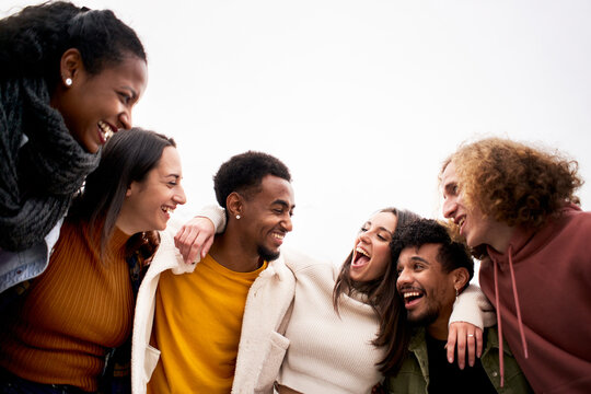 Multi-ethnic Group Of Friends Hugging And Having Fun. Isolated Young Smiling People Laughing Togethers Enjoy The Community.