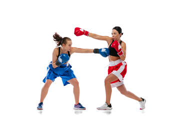 Fototapeta na wymiar Two woman professional boxers boxing isolated on white studio background. Couple of fit muscular caucasian athletes fighting. Sport, competition