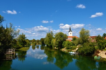 View of Krka river at Kostanjevica na Krki in Dolenjska, Slovenia with a reflection of the sky and...