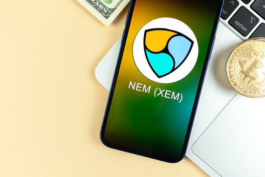 Nem XEM coin symbol. Trade with cryptocurrency, digital and virtual money, banking with mobile phone concept. Business workspace, table with laptop top view photo