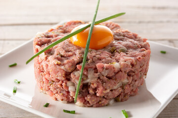 Beef steak tartare on wooden table	