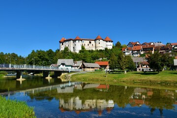 Fototapeta na wymiar View of Žužemberk castle in Suha Krajina, Dolenjska, Slovenia from across river Krka and a reflection of the castle in the water