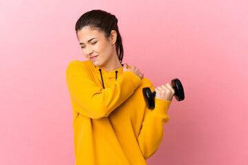 Young sport girl making weightlifting over isolated pink background suffering from pain in shoulder for having made an effort