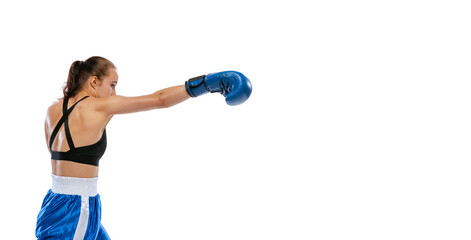 Profile view of young sportive girl, professional boxer practicing in boxing gloves isolated on...