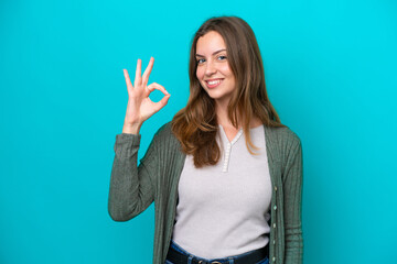 Young caucasian woman isolated on blue background showing ok sign with fingers
