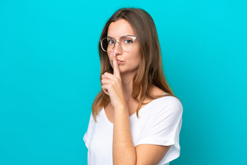 Fototapeta premium Young caucasian woman isolated on blue background With glasses and doing silence gesture