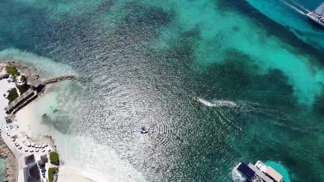 Aerial drone footage of the beautiful Pearl Island in the Bahamas near Nassau, showing the beach and lighthouse of the tropical island and beautiful green clear ocean sea water.