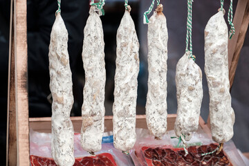 Close up of hanging salami sausages in a street market.