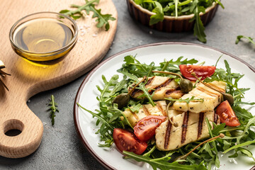 halloumi cheese salad with arugula and tomatoes. ketogenic paleo diet. Delicious breakfast or snack, Clean eating, dieting, vegan food concept. top view