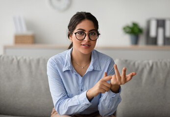 Professional female psychologist talking to camera and gesturing during therapy session at clinic, working at office - obrazy, fototapety, plakaty