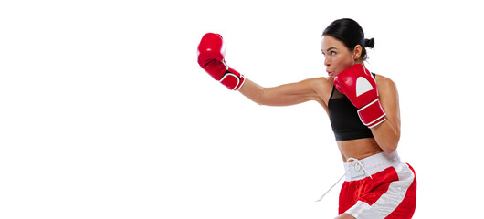 In action, motion. Young girl, professional boxer practicing in boxing gloves isolated on white...
