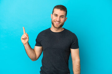 Fototapeta premium Young handsome caucasian man isolated on blue background showing and lifting a finger in sign of the best