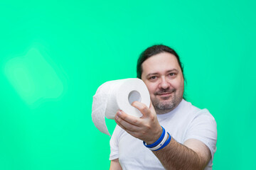 An adult, unshaven man holds out a roll of toilet paper. Bracelet in the colors of the Israel flag.