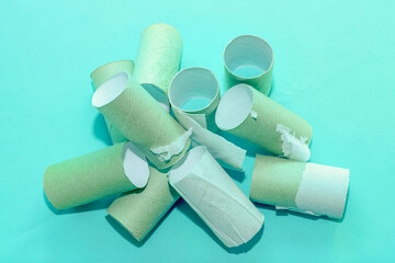 A pile of empty toilet paper tubes on a bluebackground. The concept is a global crisis and a lack of things to meet basic needs.