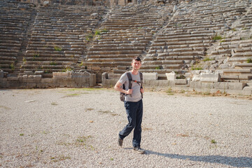 walk in Antalya Turkey on warm October afternoon, city Perge. tourist man with backpack at the ruins of ancient city of Perge