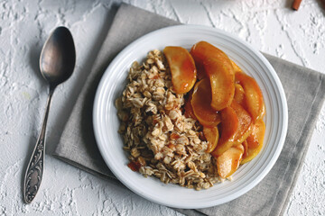 Oatmeal with caramelized apple and cinnamon on a plate. Healthy breakfast. Breakfast restaurant.