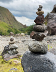 Fototapeta na wymiar Pyramid of stones on the backdrop of mountains in the Elbrus region. Balance, meditation and stability concept