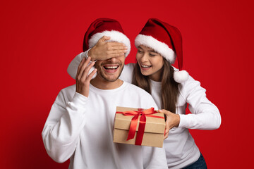 Gift For You. Woman In Santa Hat Making Christmas Surprise To Boyfriend