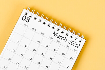 March 2022 desk calendar on light yellow background.