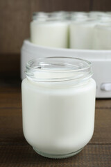Obraz na płótnie Canvas Glass jar with tasty yogurt on wooden table