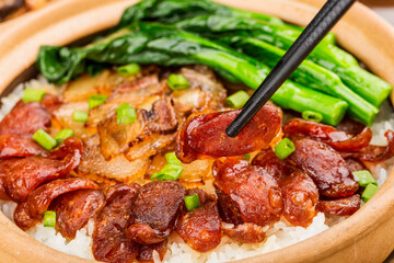 Cantonese style cooking of claypot rice with waxed meats