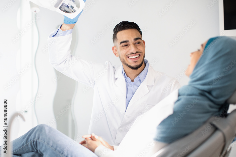 Wall mural Dental Treatment. Middle Eastern Dentist Doctor Having Checkup With Muslim Female Patient