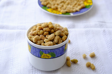 White dried mulberry, dried mulberry in bowl on white background. Copy space. Superfood, vegan, vegetarian food concept. Mulberry berries macro, selective focus. Healthy snack.