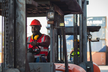 Fototapeta na wymiar Male worker in uniform and helmet driving and operating on diesel container forklift truck at commercial dock site.