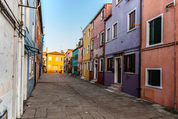 Fototapeta na wymiar Colorful island of Burano,Venice landmark,Italy.Most colorful place in world with leaning bell tower,canals,small houses.Tranquility and calmness in Venetian Lagoon.Cobblestone street of fishing town