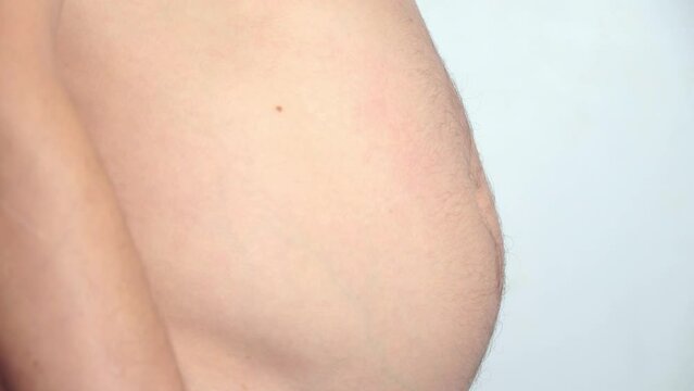 Close-up, male belly, overweight. young man with bare fat belly shakes fat folds on his stomach, obesity, health, beer belly. man himself is pumped up with muscles. Problem area of body. hormones.