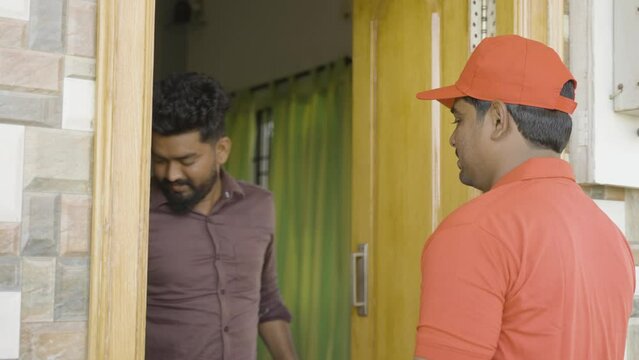 Focus on delivery boy, unsatisfied Customer returning order to delivery boy at home - concept of hassel free product returns at door step, online shopping and e-commerce purchase problems