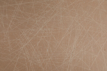 Old fiberboard with scratches as background, closeup