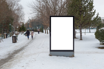 Blank billboard in snowy weather in a public park