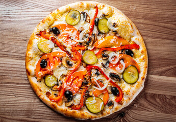 vegetarian pizza with Mozzarella cheese, grilled zucchini, mushrooms, red onion, pepper and olive. Italian pizza on wooden table background