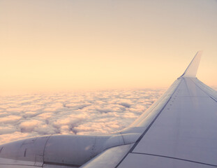 Fototapeta na wymiar wing of airplane flying over cloudy sky