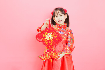 Chinese girl with traditional dressing up and holding a "Fu" means "lucky" greeting sign
