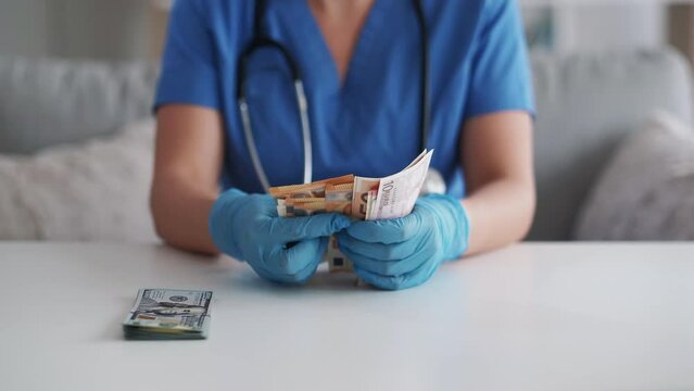 Medical bribery. Healthcare corruption. Health service cost. Unrecognizable female doctor in gloves counting cash money 50 bill Euro banknotes.